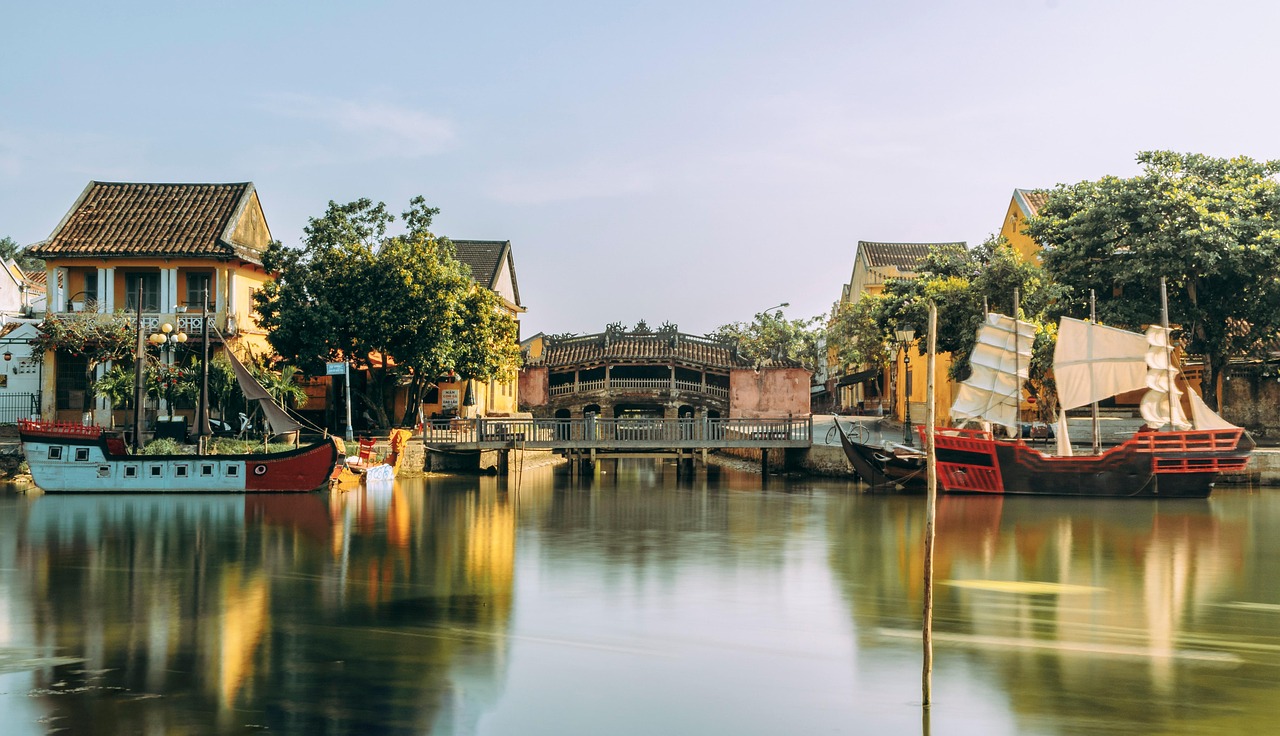 hoi an town canal vietnam ancient town bridge reflection water channel waterway boat houses buildings old town nature urban