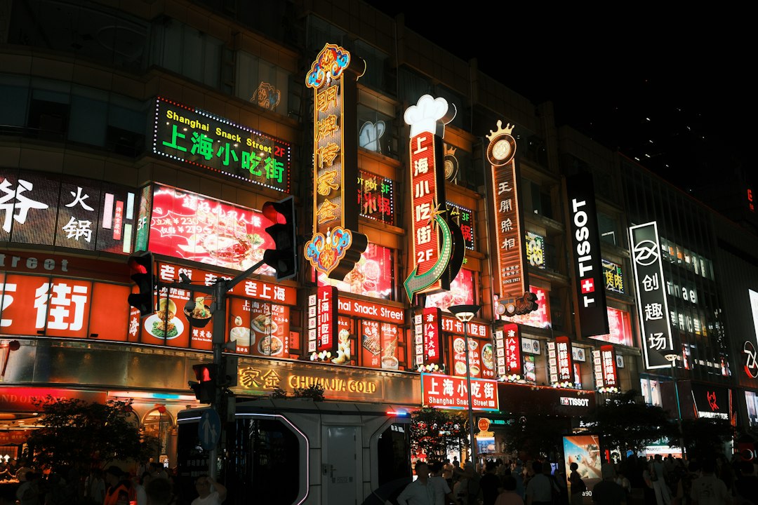 Bright neon signs on a multi-story building at night in Shanghai