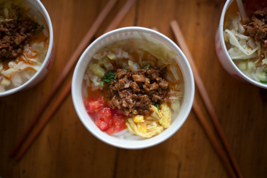 three bowls of food with chopsticks on a table