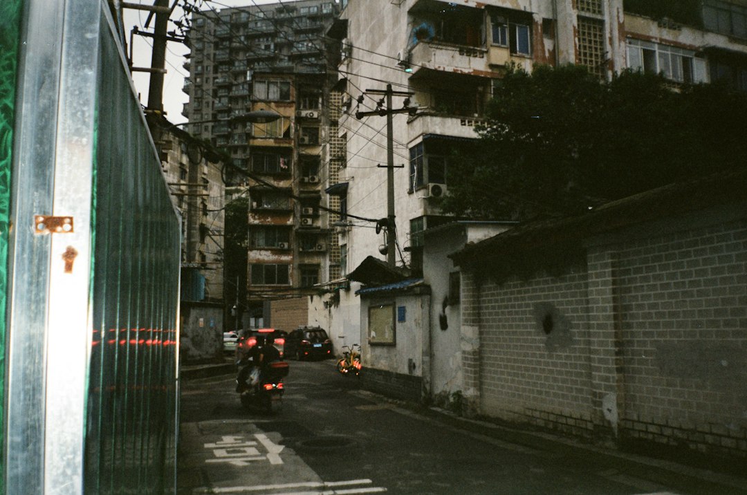 A narrow urban street with old buildings and a scooter